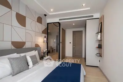 Modern bedroom with stylish decor and geometric accent wall, featuring cozy bedding and ambient lighting.