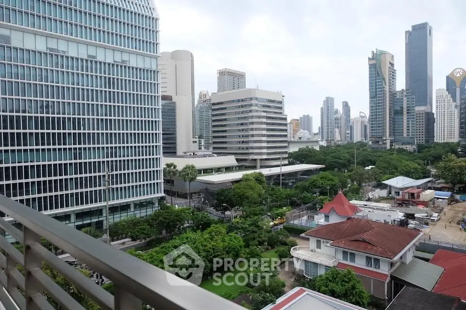 Stunning cityscape view from a high-rise balcony overlooking lush greenery and modern skyscrapers.