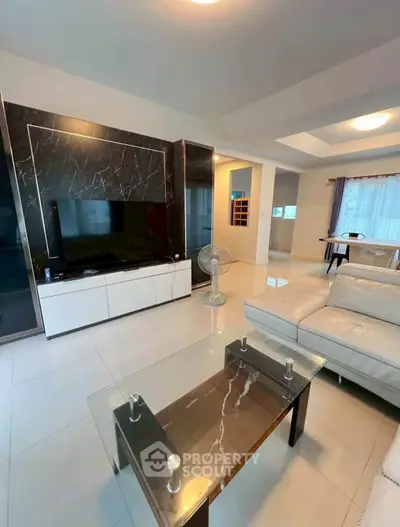 Spacious modern living room with elegant marble accents and sleek furniture design.