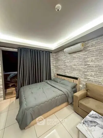 Modern bedroom with stylish brick wall, cozy bed, and air conditioning in a chic apartment.