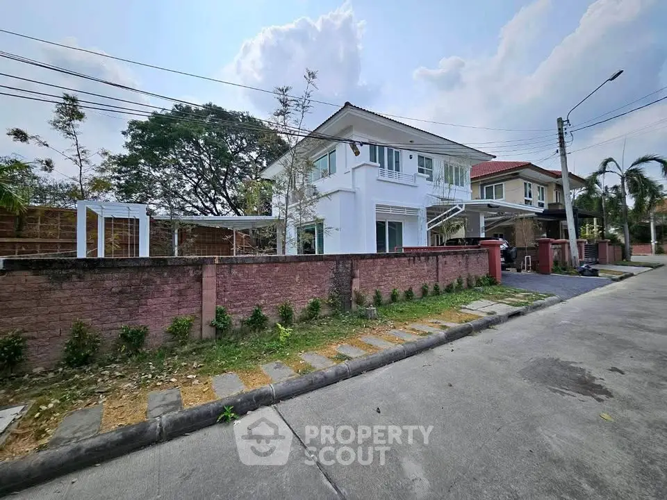 Charming suburban house with spacious driveway and lush greenery, perfect for family living.