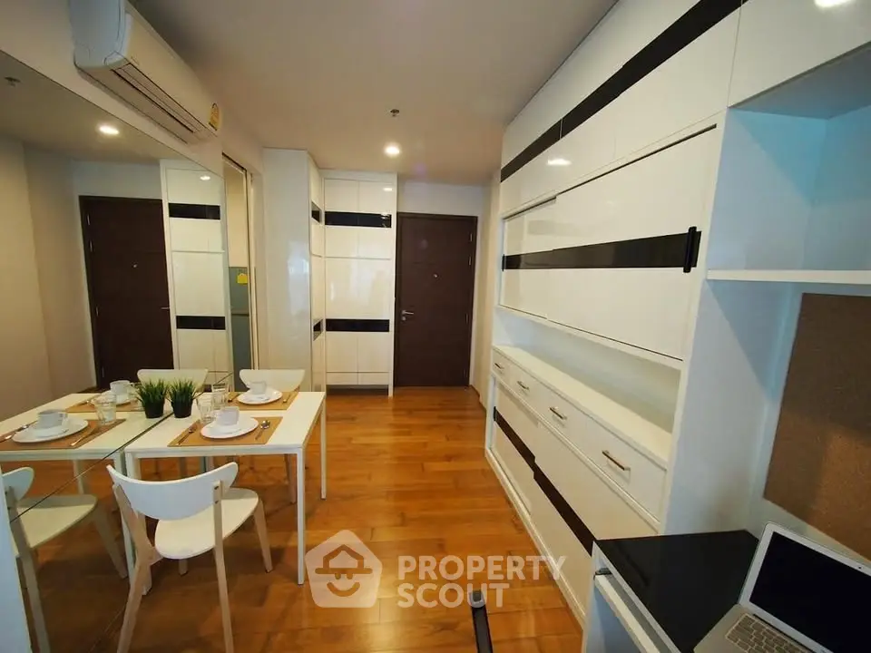 Modern dining area with sleek white cabinetry and wooden flooring
