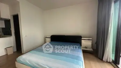 Modern bedroom with large window and stylish bed in a contemporary apartment.