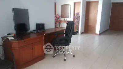 Spacious study area with desk, chair, and TV in a modern home.