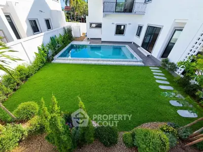 Luxurious modern home with private pool and lush green garden, perfect for relaxation and entertainment.