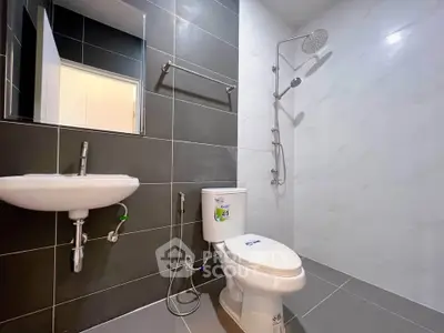 Modern bathroom with sleek fixtures and rainfall showerhead in contemporary design.