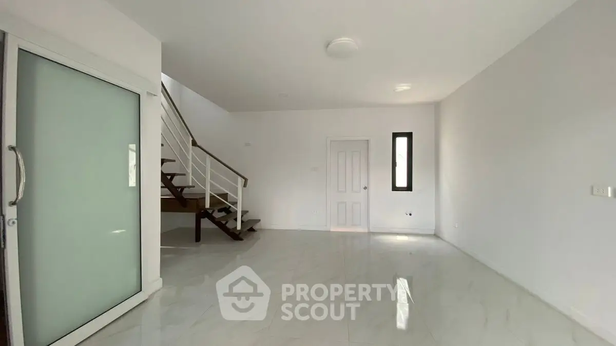 Spacious modern interior with sleek staircase and glossy tile flooring
