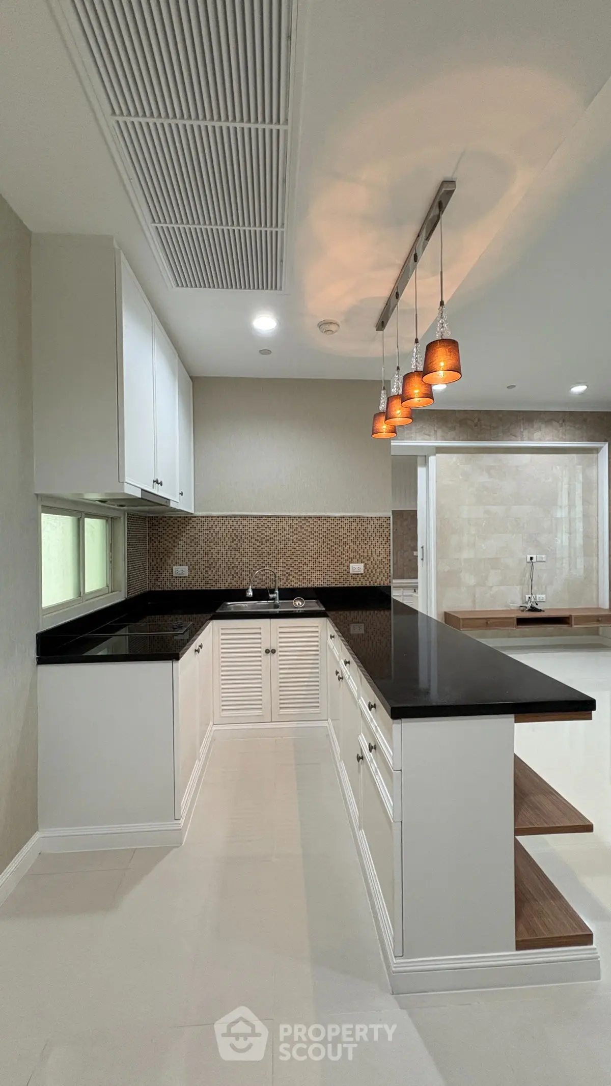Modern kitchen with sleek black countertops and stylish pendant lighting