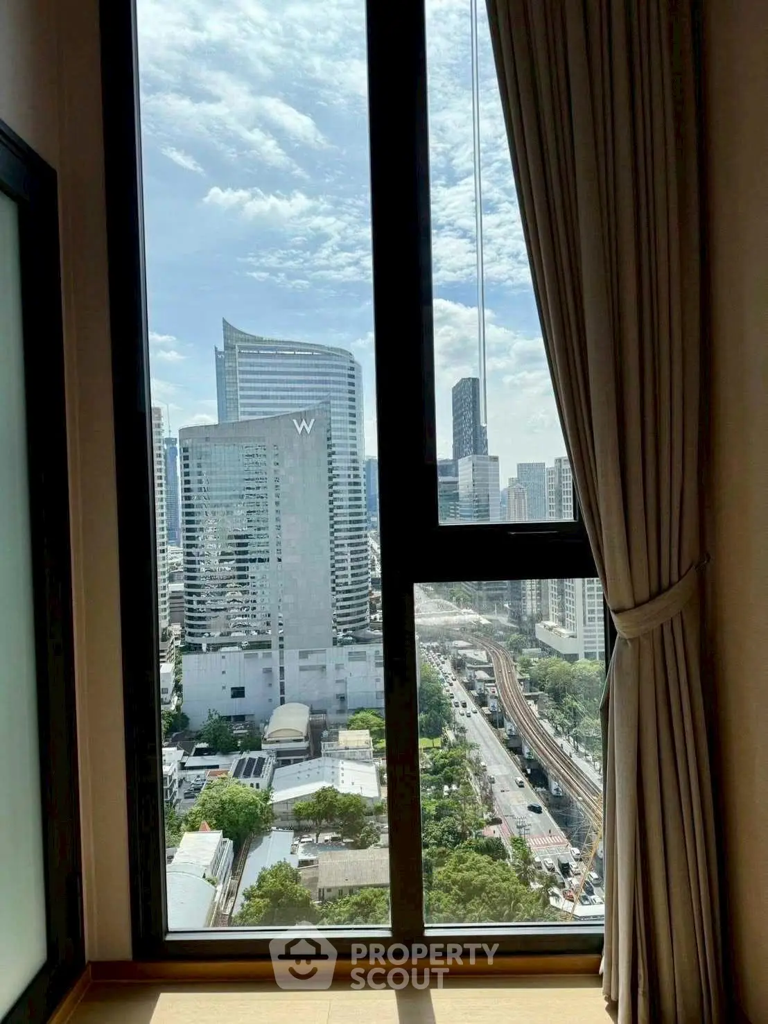 Stunning city view from high-rise apartment window with modern skyline.