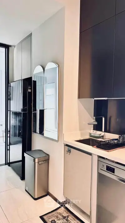 Modern kitchen with sleek appliances and minimalist design, featuring a gas stove and stainless steel finishes.
