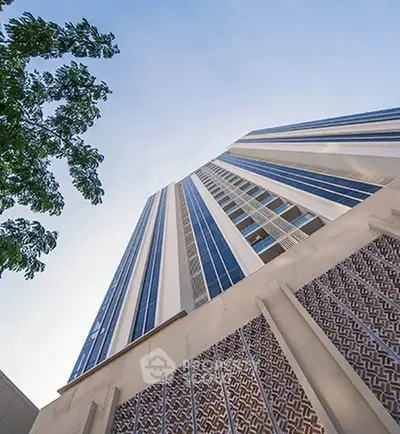 Stunning modern high-rise building with unique architectural design and clear blue sky backdrop.