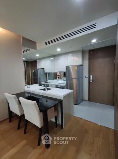Modern kitchen with sleek appliances and dining area in a stylish apartment