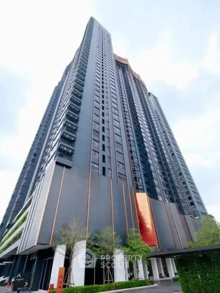 Stunning modern high-rise building with sleek design and lush greenery at the base.
