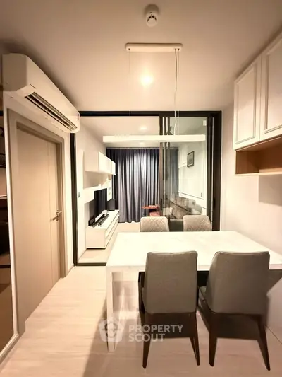 Modern apartment interior with dining area and living room, featuring sleek furniture and ambient lighting.