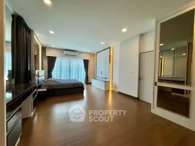 Spacious modern bedroom with elegant decor and large windows