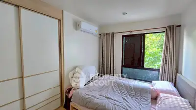 Cozy bedroom with large window and air conditioning unit