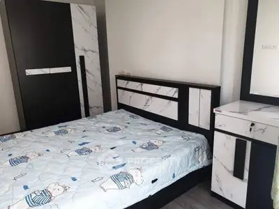 Modern bedroom with stylish marble-patterned furniture and cozy bedding.