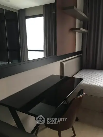 Modern study area with sleek black desk and comfortable chair in stylish apartment.