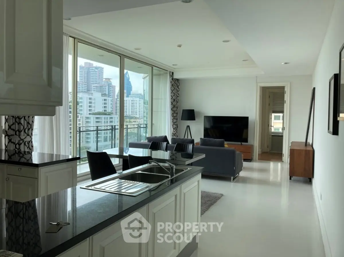 Modern open-layout living room with city view, featuring sleek kitchen and stylish furnishings.