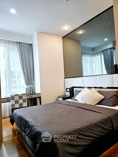 Modern bedroom with stylish decor and large windows for natural light
