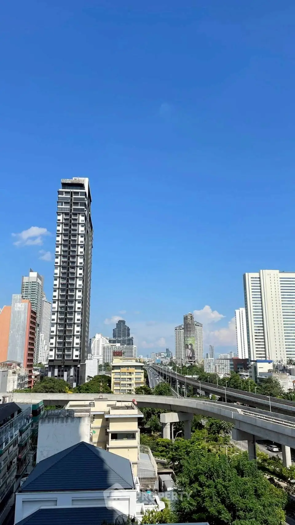 Stunning cityscape view with modern high-rise buildings under a clear blue sky, showcasing urban living at its finest.