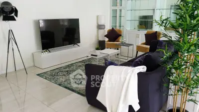 Stylish living room with modern decor, large TV, and cozy seating area.