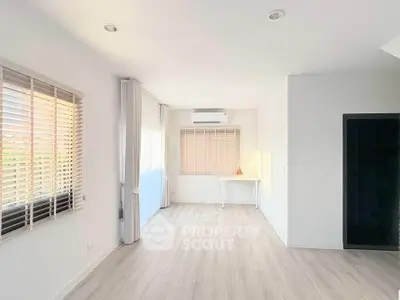 Spacious and bright room with large windows and modern flooring, perfect for versatile living space.