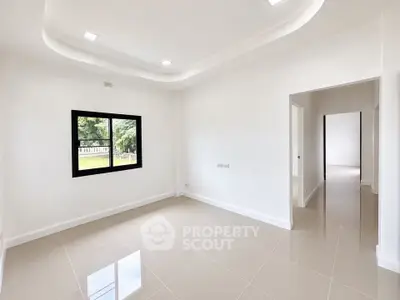 Spacious modern living room with large window and glossy tiled floor