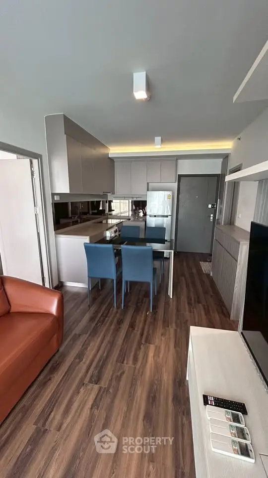 Modern open-layout kitchen and living room with sleek design and wooden flooring