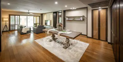 Spacious open-plan living and dining area with elegant wooden flooring and modern decor.