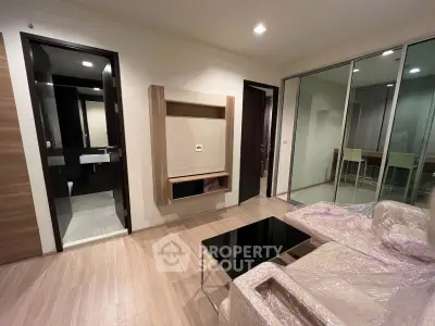 Modern living room with sleek design and open layout, featuring a stylish coffee table and wrapped furniture.