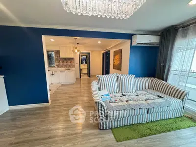Stylish living room with striped sofa and elegant chandelier in modern apartment.