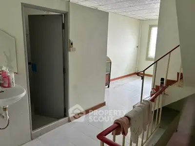 Spacious interior with staircase and natural light, ideal for renovation.