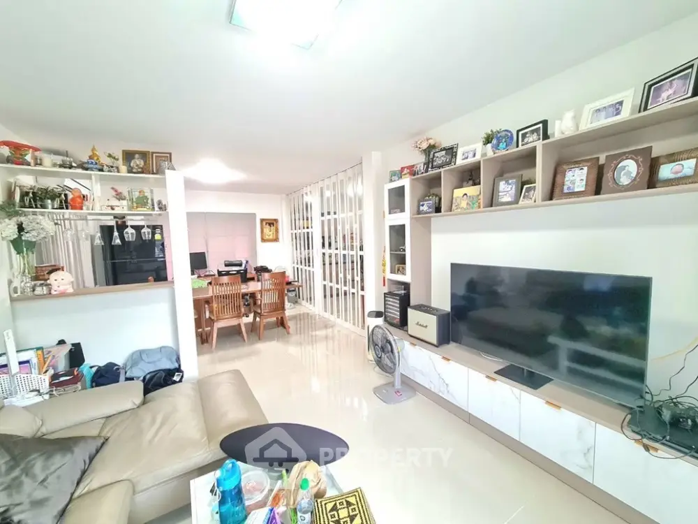Spacious living room with modern decor and large TV, perfect for family gatherings.