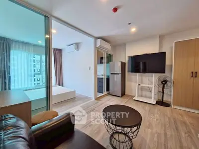Modern living room with open layout, featuring sleek furniture and large windows for natural light.