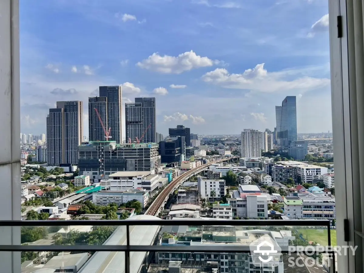 Stunning cityscape view from high-rise balcony with modern skyline and clear blue sky.