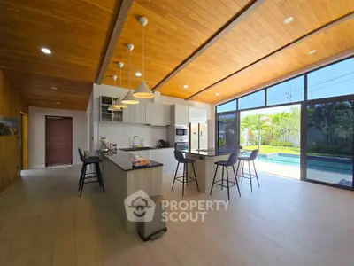 Spacious modern kitchen with open layout and pool view, featuring sleek design and ample natural light.