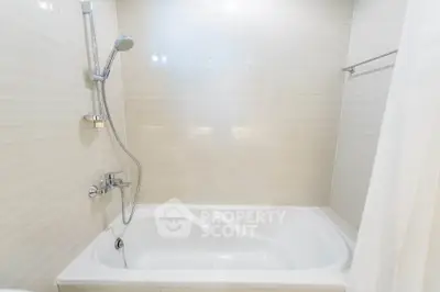 Modern bathroom with sleek bathtub and shower in elegant neutral tones.