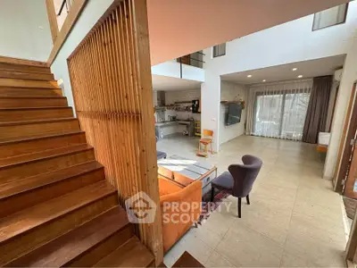 Spacious modern living room with open kitchen and wooden staircase