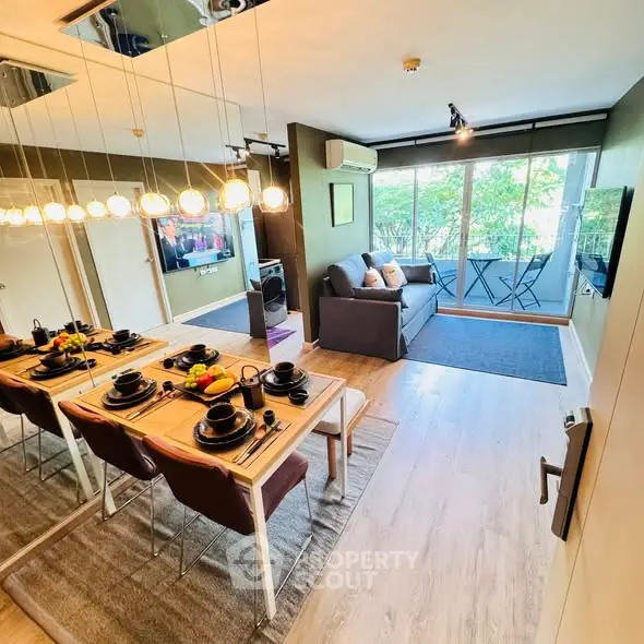 Modern living room with dining area and balcony access, featuring stylish decor and natural light.