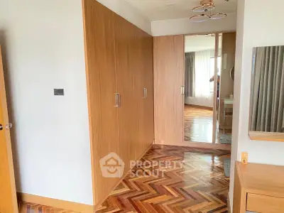 Spacious bedroom with elegant parquet flooring and ample closet space