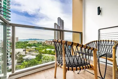 Stunning balcony view with modern chairs overlooking cityscape and lush greenery.