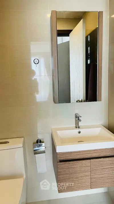 Modern bathroom with sleek vanity and mirror in a contemporary apartment.