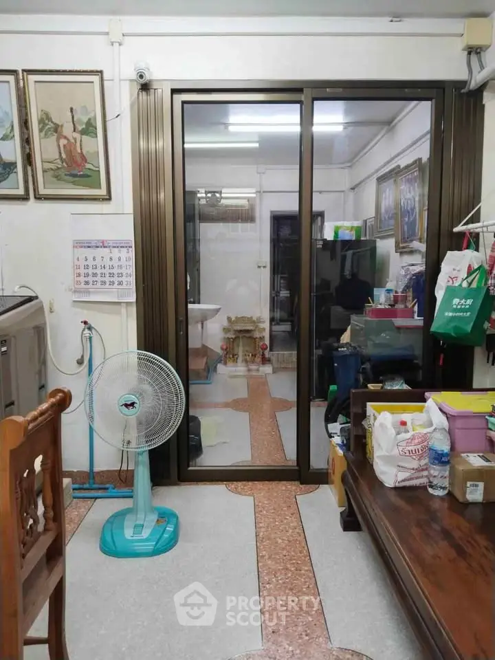 Cozy interior with sliding glass doors, fan, and traditional decor, perfect for a comfortable living space.