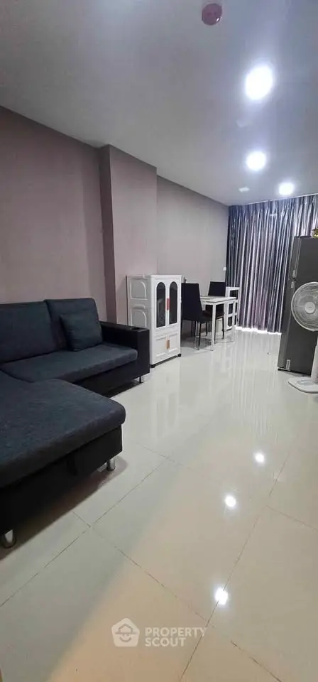 Spacious modern living room with sleek furniture and ample natural light.