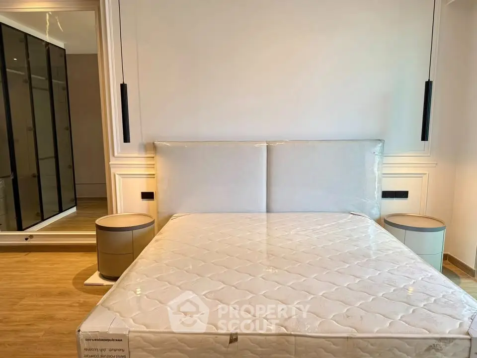 Modern bedroom with elegant design, featuring a stylish bed and sleek mirrored wardrobe.