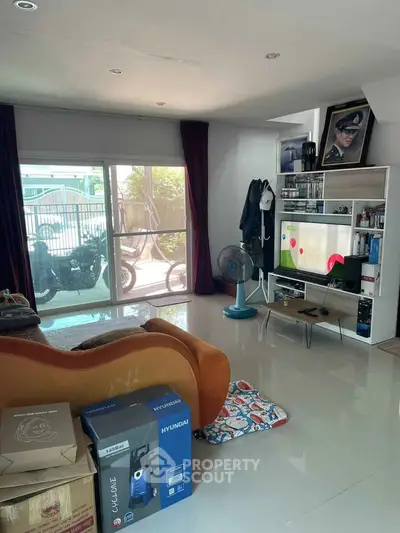 Spacious living room with modern decor and large sliding glass doors leading to a balcony.