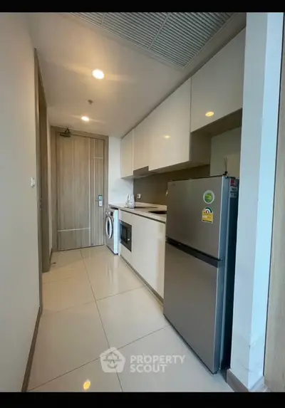 Modern kitchen with sleek appliances and ample storage in a stylish apartment.