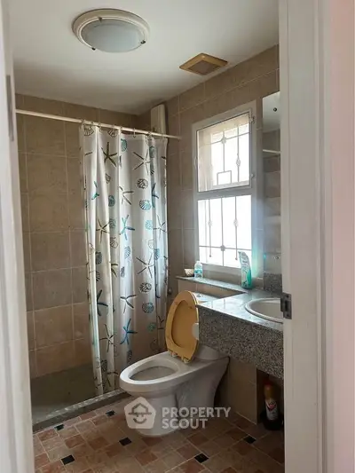 Charming bathroom with tiled shower and modern fixtures in cozy home.