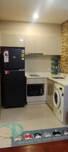 Modern kitchen with sleek appliances including fridge, oven, and washing machine.